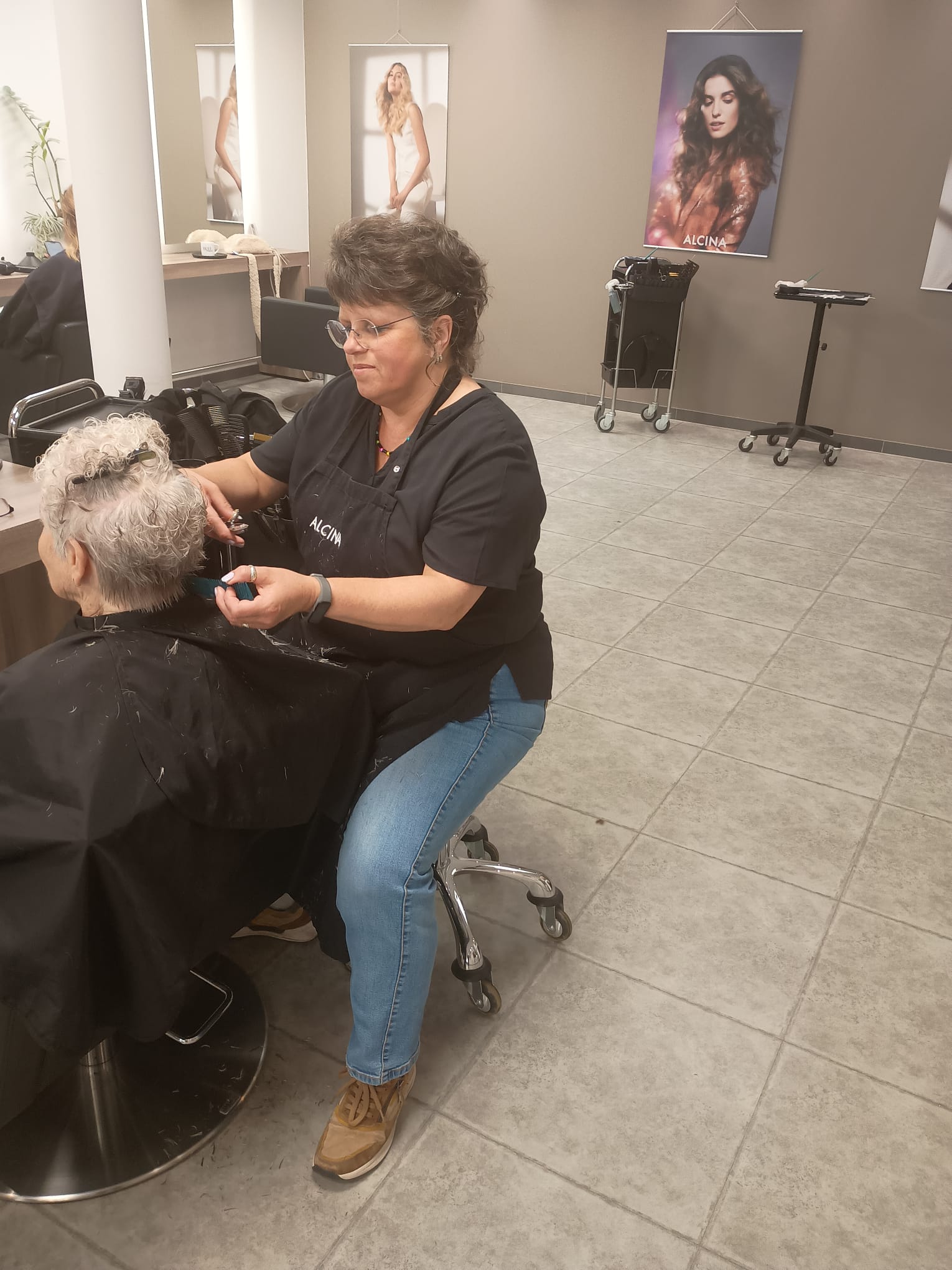 Eine Friseurin schneidet einer Kundin die Haare in einem modernen Friseursalon. 